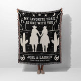 Cowboy and cowgirl on two horses 2nd anniversary gift woven throw blanket with desert-themed design and text, held by a person on a white background