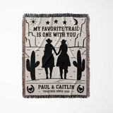 Cowboy and cowgirl on two horses cotton anniversary gift woven throw blanket full view with cowboy design and text on a white background