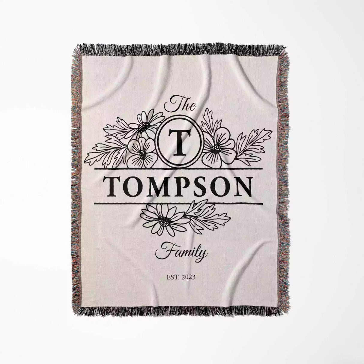 Custom family name blanket with 'The Tompson Family' design flat lay on a white background