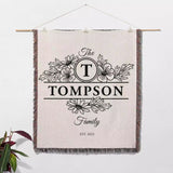 Custom family name blanket with 'The Tompson Family' design hanging on a white wall.