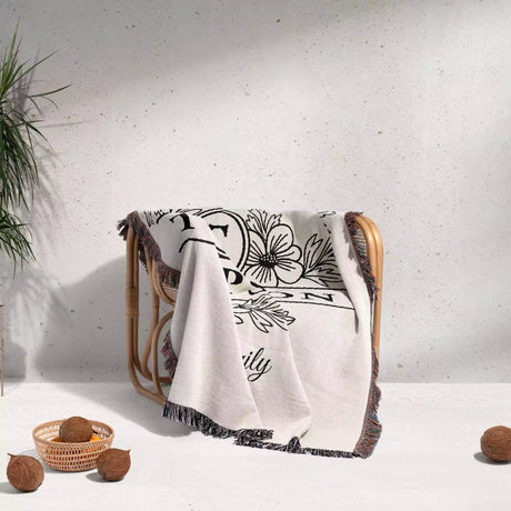 Custom family name blanket with floral design and text draped over a chair on a light background