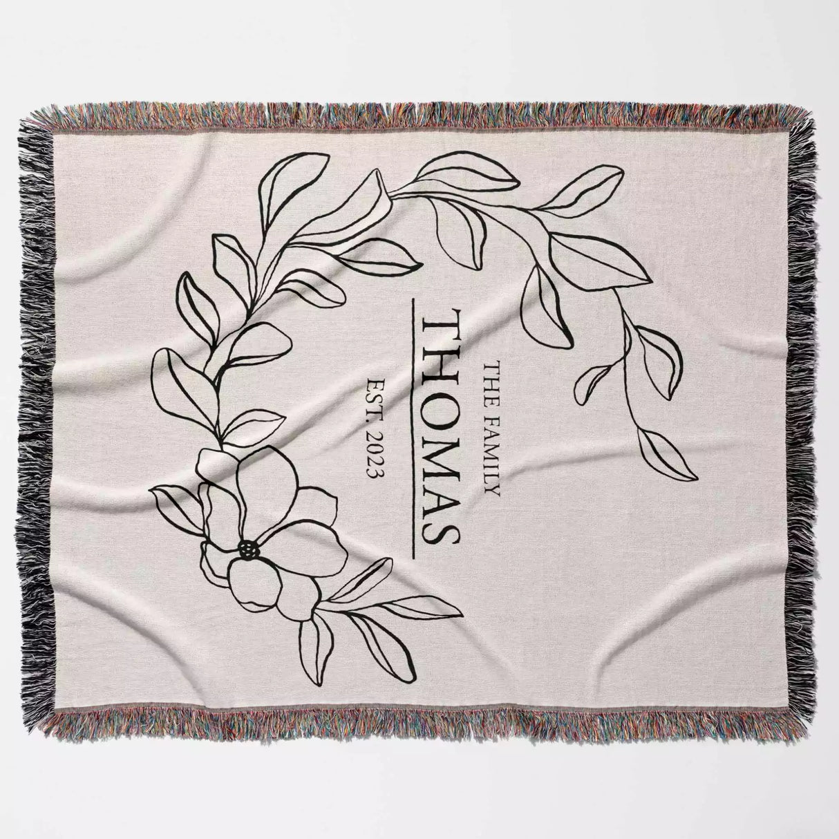 Custom family name cotton throw blanket with floral design and text full view on a light background