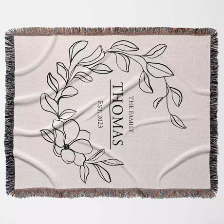 Custom family name cotton throw blanket with floral design and text full view on a light background