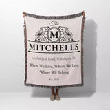 Custom family name and address blanket with 'The Mitchells' design and text held by a person on a white background