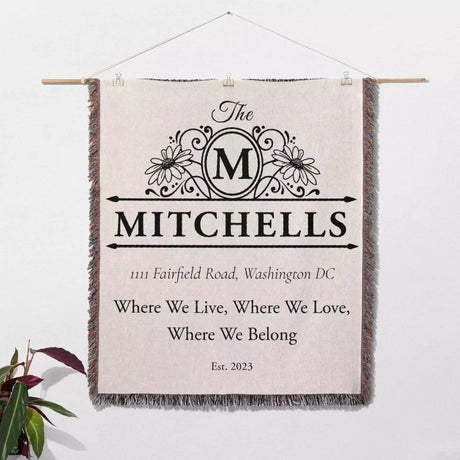 Custom family name and address blanket wall hanging with 'The Mitchells' family name and address on a light background.