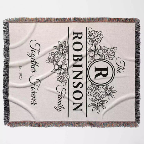Custom last name cotton blanket with floral design, 'Robinson Family' text, and monogram full view on a light background
