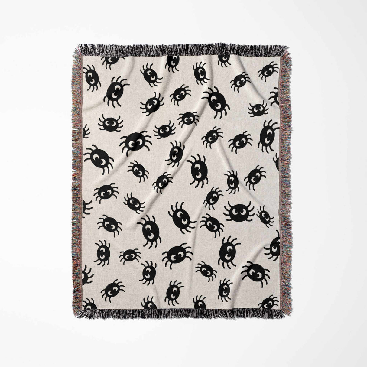 The Cute Halloween Blanket is laid out vertically, emphasizing its size and design. The image shows a full view of the blanket, adorned with charming black spiders scattered across an off-white background. The multicolored fringe along the border adds a delightful splash of color to the playful spider design.