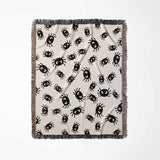 Cute spiders woven throw blanket for Halloween décor full view on a beige background.