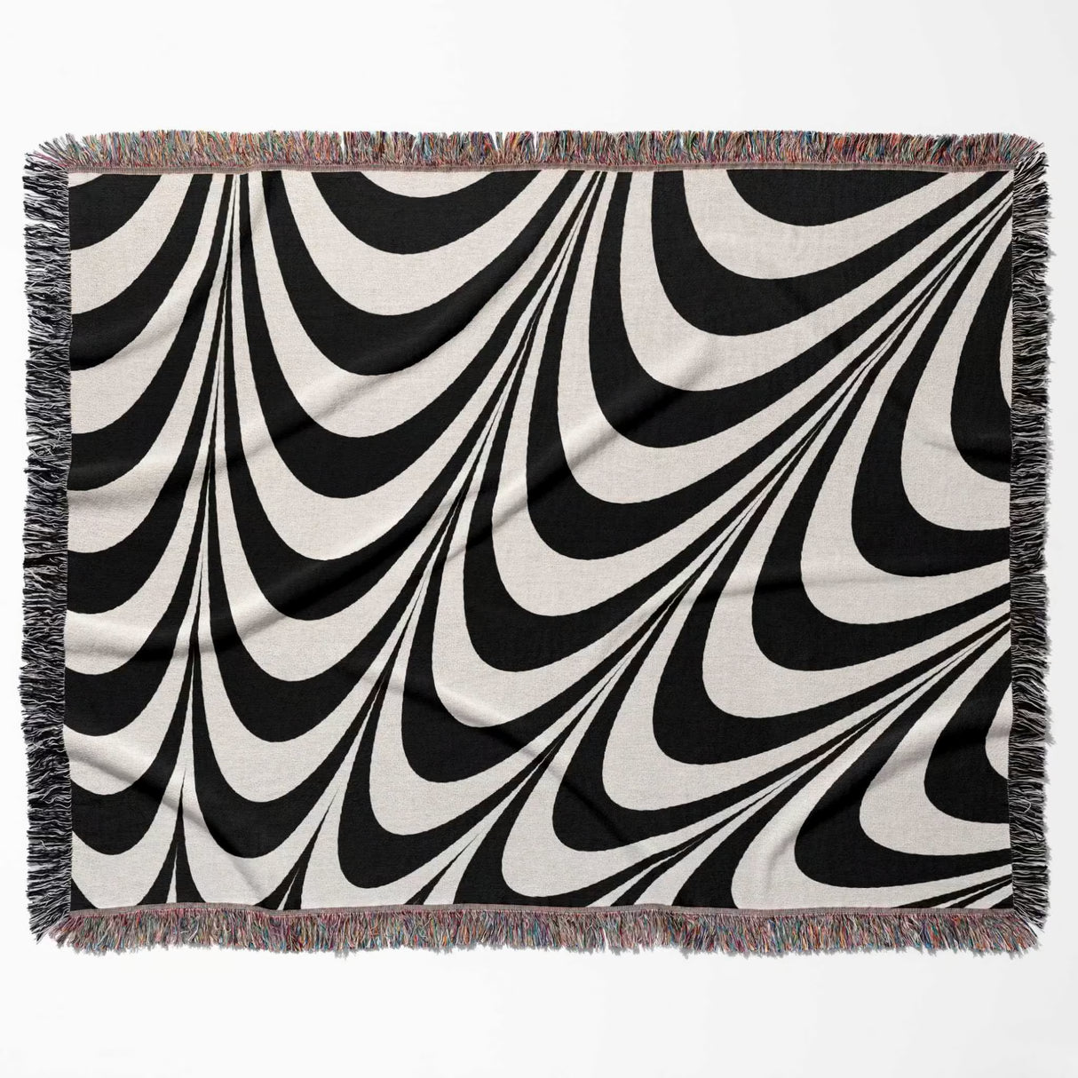 Black and white decorative abstract waves woven blanket throw tapestry with fringed edges flat lay on a white background.
