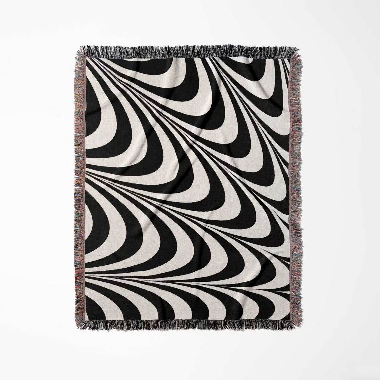 Black and white decorative abstract waves woven blanket throw tapestry full view on a light gray background.