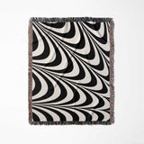 Black and white decorative abstract waves woven blanket throw tapestry full view on a light gray background.