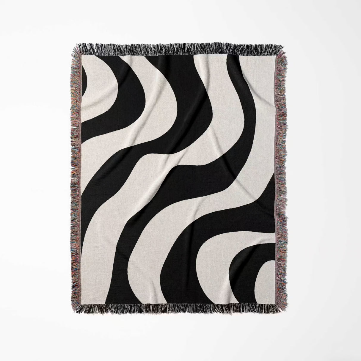Black and white decorative modern woven blanket throw tapestry with fringe full view on a light gray background