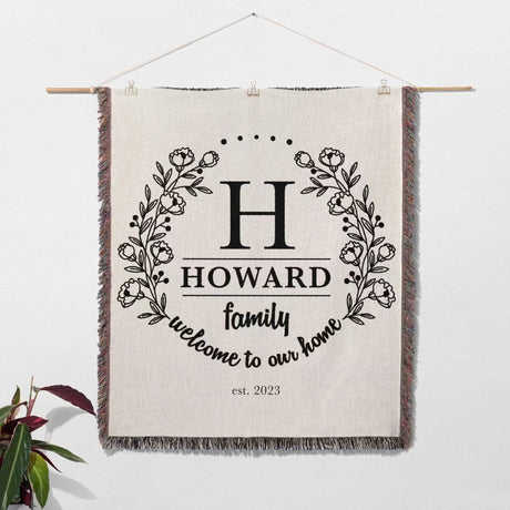 Family monogrammed woven throw blanket for couch and bed wall hanging with floral design and text on a white background