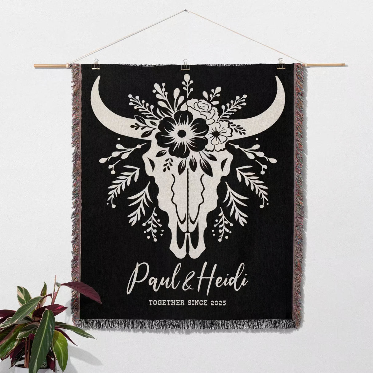 Floral cow skull 2nd anniversary gift woven throw blanket with white bull skull design and custom text, hanging on a wall.