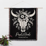 Floral cow skull 2nd anniversary gift woven throw blanket with white bull skull design and custom text, hanging on a wall.