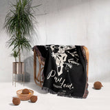 Floral cow skull 2nd anniversary gift woven throw blanket with white floral design and text draped over a chair against a light gray wall.