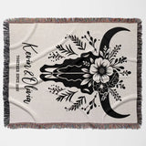 Floral cow skull cotton anniversary gift woven throw blanket flat lay with floral design and text on a white background