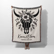 Floral cow skull cotton anniversary gift woven throw blanket held by a person with bull skull design and personalized text on a white background