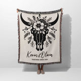 Floral cow skull cotton anniversary gift woven throw blanket held by a person with bull skull design and personalized text on a white background