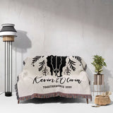 Floral cow skull cotton anniversary gift woven throw blanket with elephant design and text on a couch against a white wall.