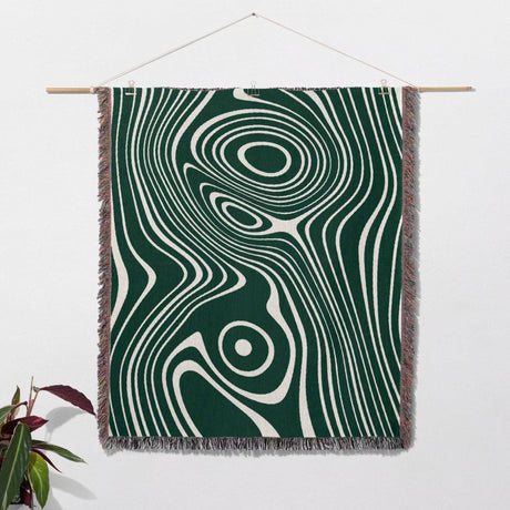 Forest green abstract woven throw blanket as woven wall art with green and white pattern on a white background