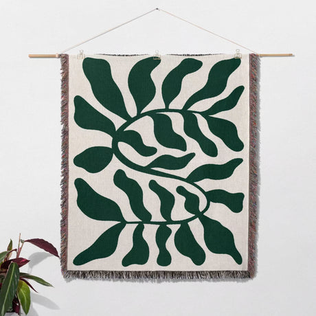 Forest green leaf Matisse throw blanket as a woven wall art hanging on a white background