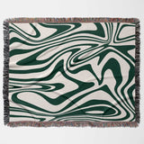 Forest green marble woven throw blanket for couch with green and white abstract pattern on a beige background