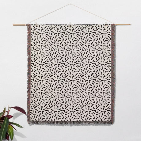 Funky squiggly woven blanket throw tapestry with black abstract pattern on a white background.