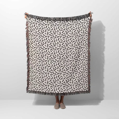 Funky squiggly woven blanket throw tapestry held by a person on a white background