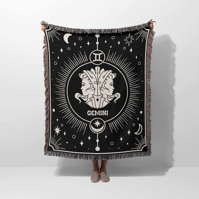 A person holds up the Gemini Zodiac Blanket, displaying the full design. The blanket's size and detailed Gemini twins symbol with celestial elements are clearly visible, demonstrating its quality and craftsmanship.