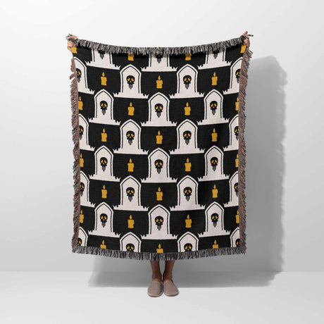 Black and white patterned throw blanket draped over a person on a white background