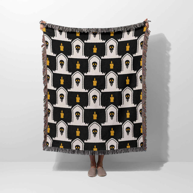 Black and white patterned throw blanket draped over a person on a white background