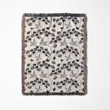 Japanese style woven blanket throw tapestry with bird and branch pattern full view on a white background.