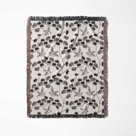 Japanese style woven blanket throw tapestry with bird and branch pattern full view on a white background.
