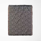 Black and white labyrinth hexagon pattern woven blanket throw with fringes full view on a white background.