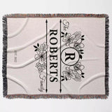 Last name monogram blanket with floral design full view and 'The Roberts Family' text on a light background