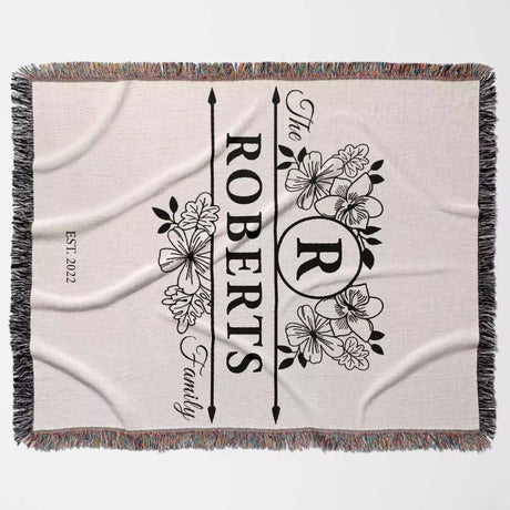 Last name monogram blanket with floral design full view and 'The Roberts Family' text on a light background