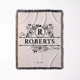 Last name monogram blanket with floral design and 'The Roberts Family' text on a white background