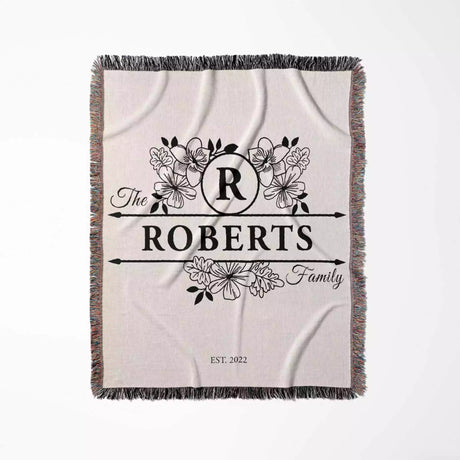 Last name monogram blanket with floral design and 'The Roberts Family' text on a white background