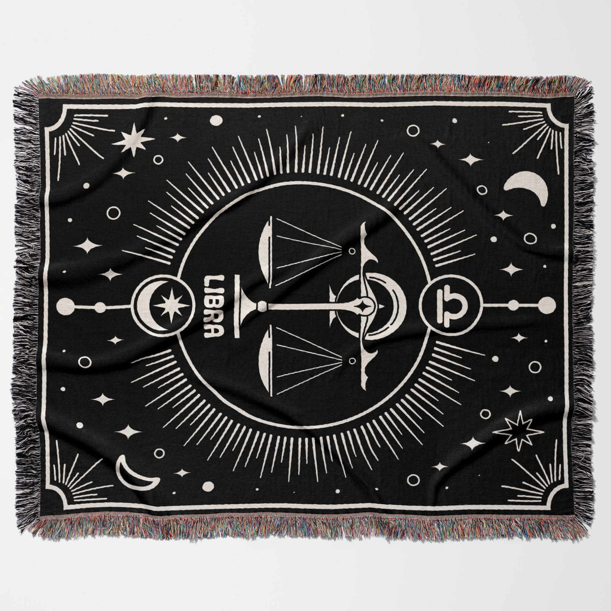 A Libra Zodiac Blanket laid flat in a horizontal position, showcasing the entire design prominently with the Libra scales symbol at the center, surrounded by celestial elements like stars and moons, and a decorative multicolor fringe around the edges.