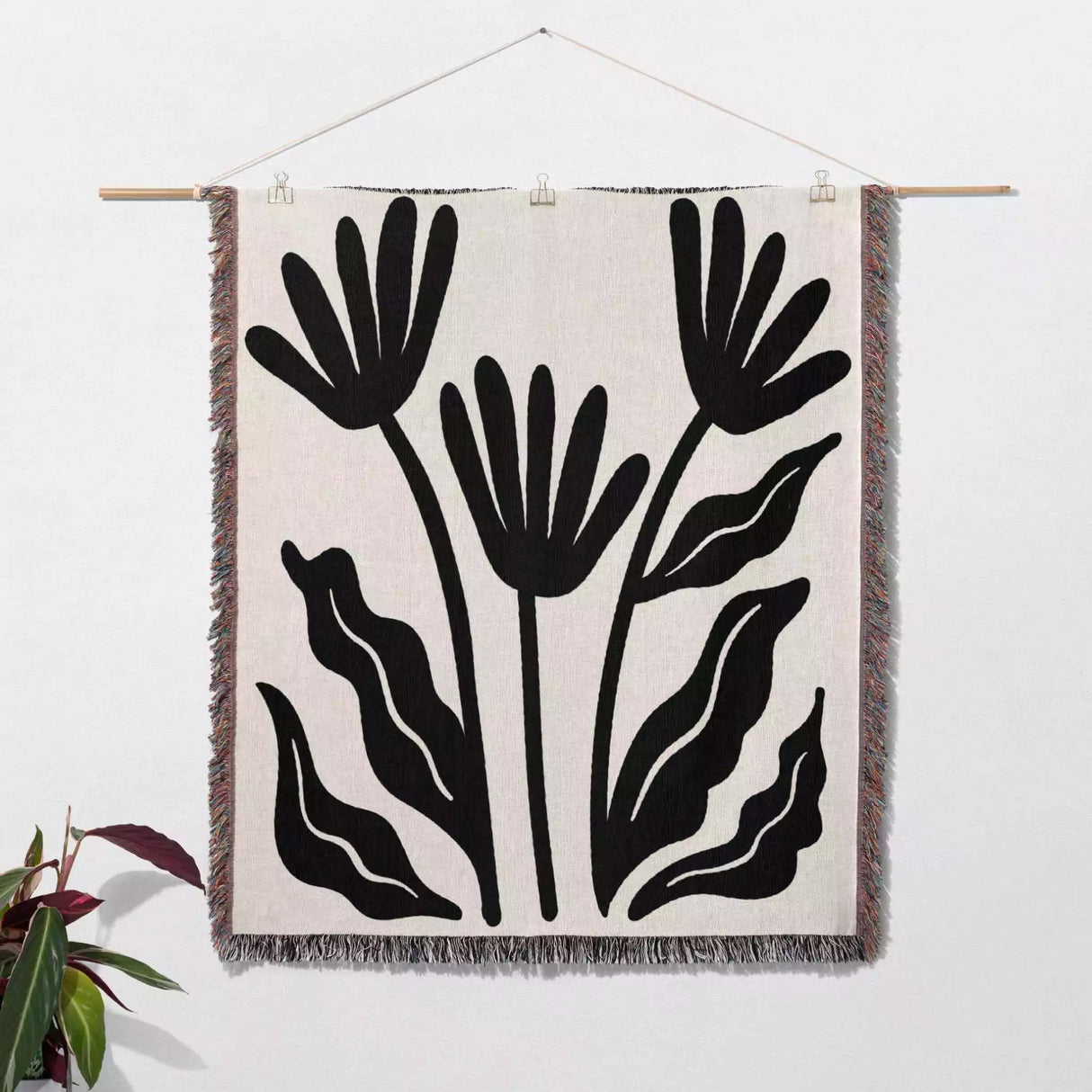 Matisse flowers black and white woven throw blanket as woven wall art with black leaf pattern on a white background