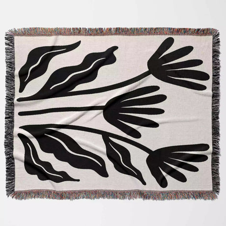 Matisse flowers black and white woven throw blanket with black leaf-like patterns on a beige background