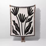 Matisse flowers black and white woven throw blanket with black leaf pattern on a white background