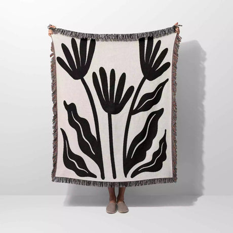 Matisse flowers black and white woven throw blanket with black leaf pattern on a white background