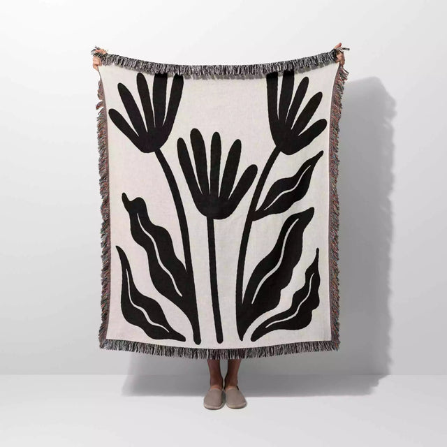 Matisse flowers black and white woven throw blanket with black leaf pattern on a white background