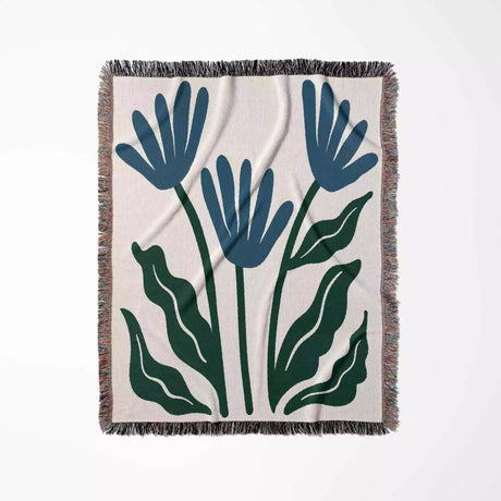 Floral-patterned Matisse inspired blue flowers woven throw blanket with blue and green leaves on a white background