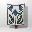 Matisse inspired blue flowers woven throw blanket with blue and green floral design on a white background
