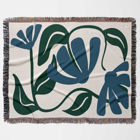 Floral patterned Matisse style blue floral cotton woven throw blanket with blue and green leaves on a beige background