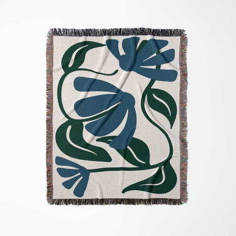 Floral patterned Matisse style blue floral cotton woven throw blanket with blue and green design on a white background