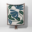 Floral patterned Matisse style blue floral cotton woven throw blanket on a white background